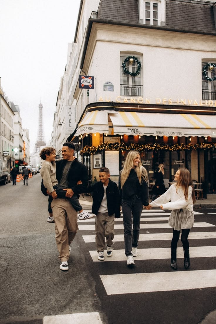 Família caminha por uma rua de Paris com a Torre Eiffel ao fundo.